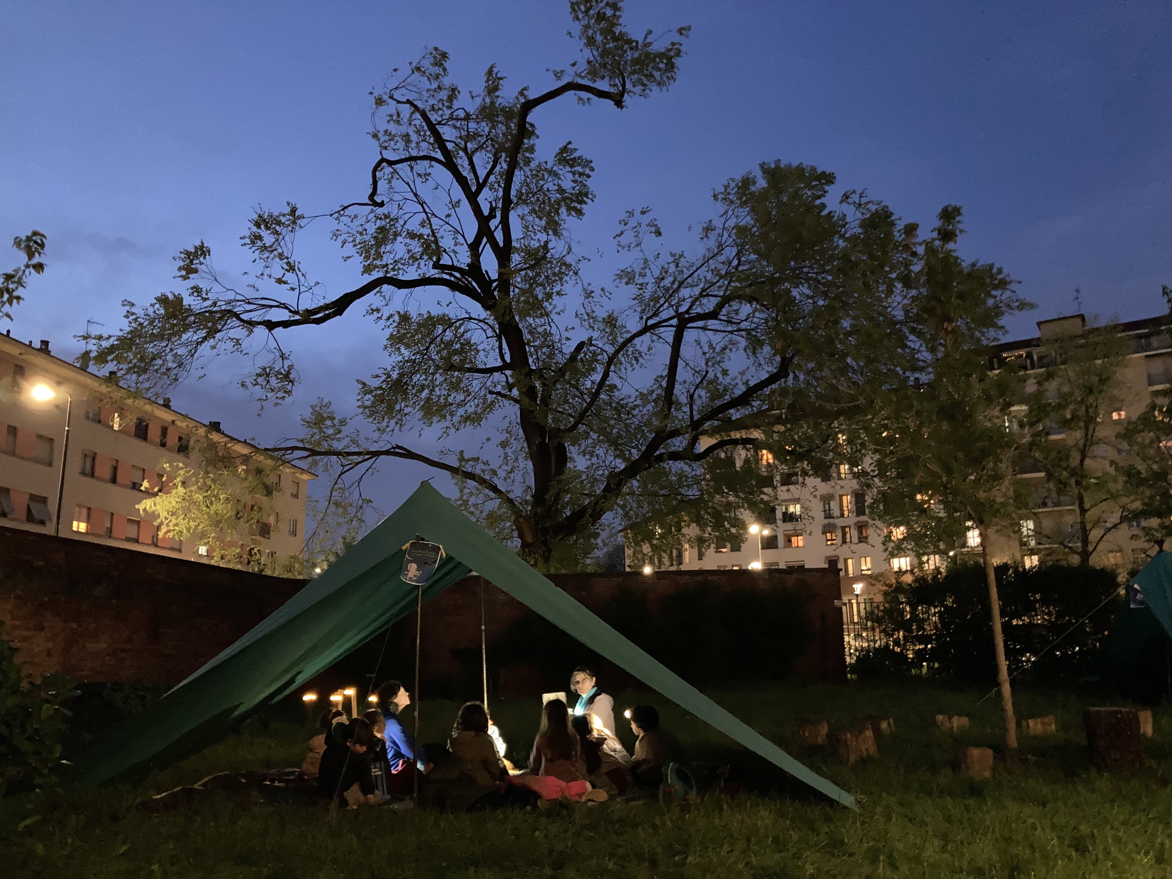 Bambini e bambine riuniti sotto una tenda durante il Bivacco Partigiano